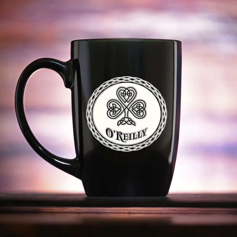 Black ceramic mug with Celtic clover design and "O'REILLY" engraved in white circular medallion with braided border