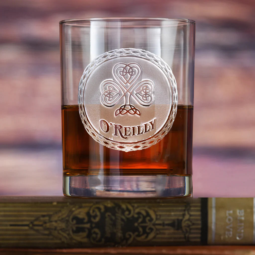 Whiskey glass filled with amber liquid, engraved with Celtic shamrock and ornate knotwork border surrounding sample name "O'REILLY