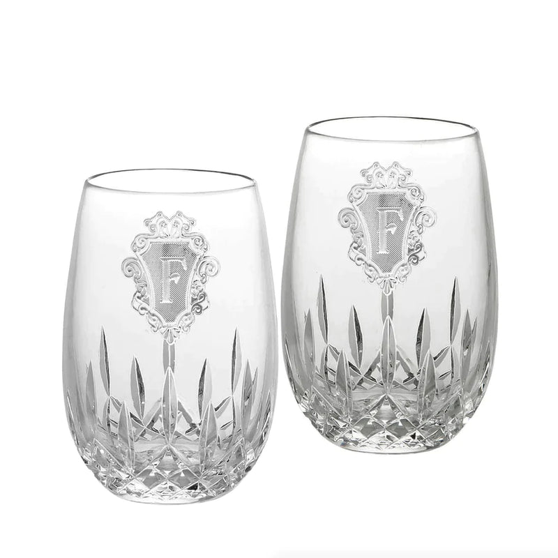 Pair of crystal stemless glasses with deep cut geometric pattern at base and ornamental monogram panel engraved on each glass