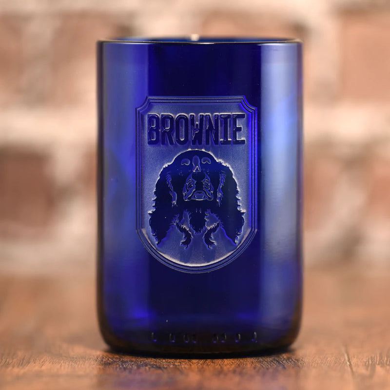 Cobalt blue recycled wine bottle glass engraved with "Brownie" text and Brownie dog breed emblem in shield design