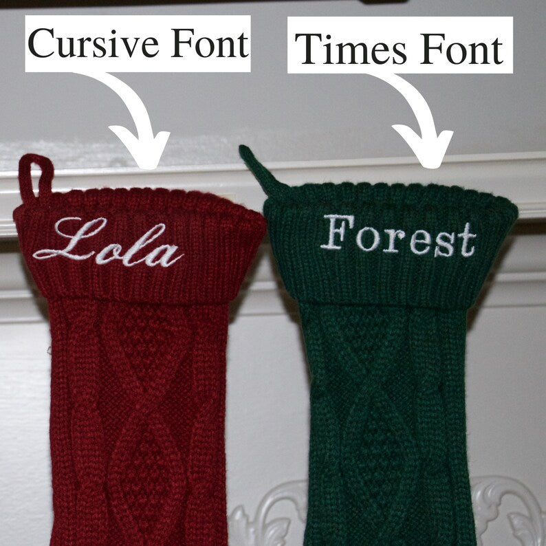 Two embroidered Christmas stockings displayed side by side: burgundy stocking with sample name "Lola" in cursive font, and forest green stocking with sample name "Forest" in Times font.
