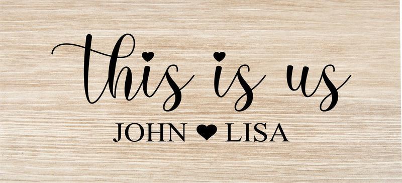 Light wood key holder engraved with sample text "This is Us" and names "John" and "Lisa" with decorative heart symbols